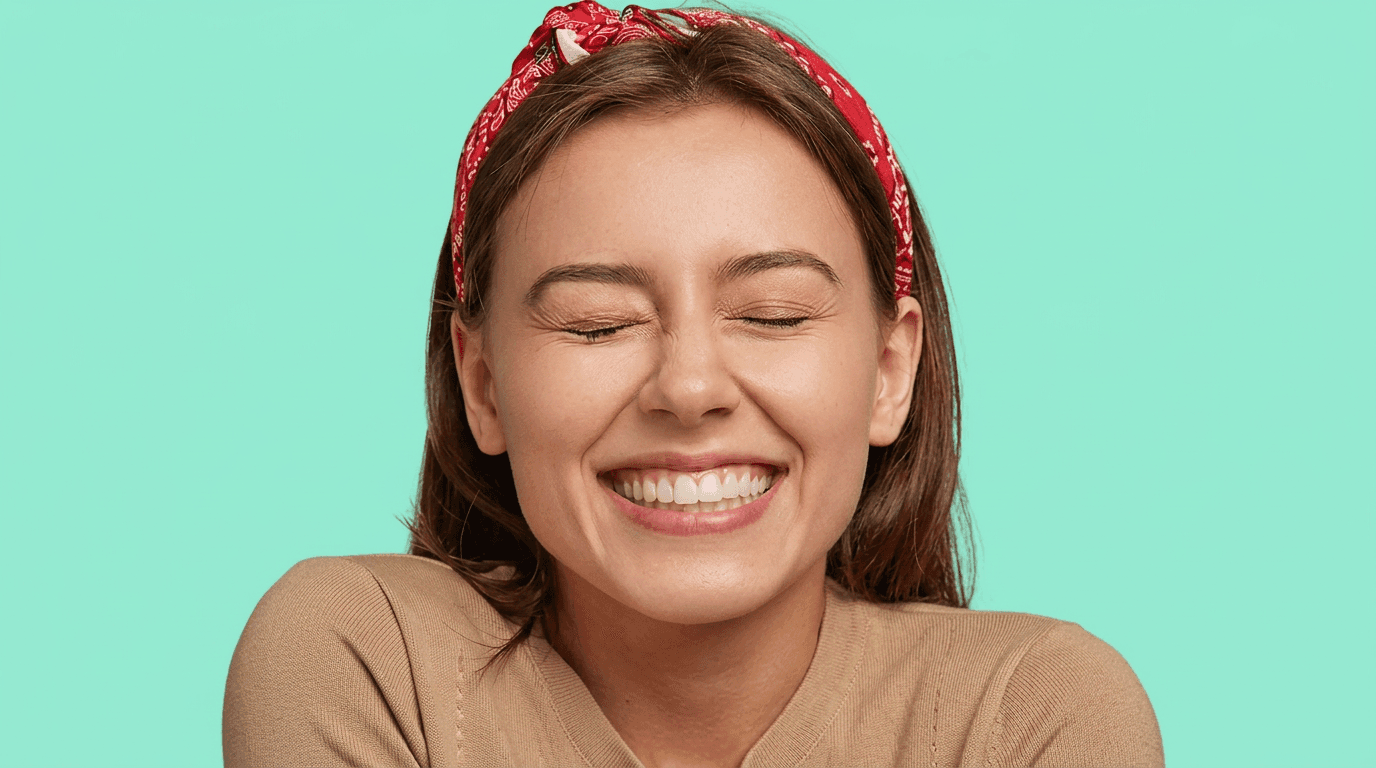 Persona sonriendo con los ojos cerrados mostrando sus dientes